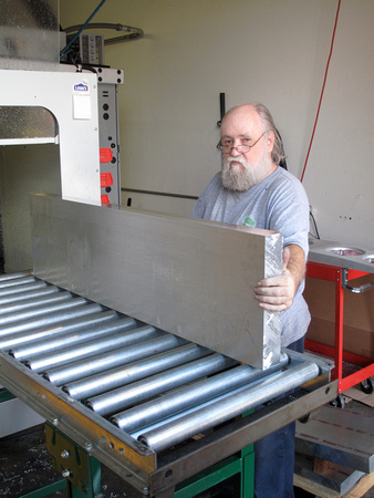 Aluminum Bar Being Rolled Into a CNC Machine